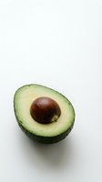 Fresh avocado half with pit isolated on white background for healthy eating and cooking concepts.