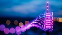 Glowing purple spiral light trails create dynamic motion effect against dark blue night sky with soft bokeh circles, modern abstract light painting.