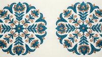 Teal and beige floral embroidery medallions on cream fabric, featuring symmetrical botanical motifs with ornate scrollwork and blooms.
