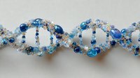 Sparkling blue and silver beaded DNA helix structure on light background, showcasing genetic science concept for educational or medical design.