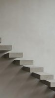 Modern minimalist concrete floating staircase against white wall creating geometric shadows in contemporary interior architecture design.