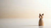 Minimalist wooden cat figurine on clean white surface with soft beige background for home decor and craft projects.