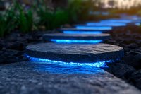 Glowing blue stepping stones create magical pathway through garden at dusk, illuminated circular pavers provide enchanting walkway lighting effect.