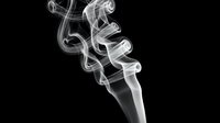 Elegant white smoke swirling gracefully against a dark black background, creating abstract curling shapes and flowing patterns.