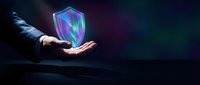 Hand holding glowing neon shield with digital security waves on dark background, representing cybersecurity protection and data defense for technology concepts.