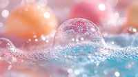 Frozen soap bubble with delicate crystalline patterns on snowy surface against pink and blue bokeh background creates magical winter macro photography effect.