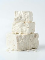 Stacked blocks of fresh white cheese isolated on neutral background, ready for culinary and food photography design projects.