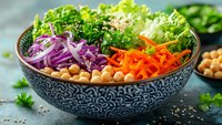 Fresh colorful vegetable bowl with lettuce, purple cabbage, carrots, chickpeas and herbs for healthy meal prep and clean eating lifestyle.