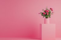 Pink roses in matching vase on geometric pedestal against monochromatic pink background, creating minimalist aesthetic for feminine branding.