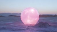 Glowing pink sphere illuminates surreal desert landscape at dusk, casting ethereal light across sand dunes and distant mountains against purple twilight sky.
