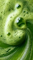 Macro shot of green matcha tea foam with bubbles and swirling pattern. Fresh organic beverage texture showing creamy froth and natural movement.