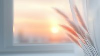 Delicate dried pampas grass stems silhouetted against soft window light during golden sunset, creating peaceful minimalist home interior atmosphere.