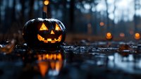 Glowing carved pumpkin with classic jack-o-lantern face reflects in puddle at dusk, orange lights twinkle in dark misty forest background creating spooky atmosphere.