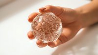 Human hands holding transparent glass sphere with intricate brain pattern inside, symbolizing mental health, neuroscience and cognitive protection concepts.