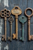 Collection of vintage ornate skeleton keys arranged on weathered blue wooden background, featuring rustic patina and decorative designs in brass, copper and verdigris finishes.