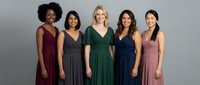 Five diverse women in elegant evening gowns standing together, showcasing different dress styles and colors for formal events, weddings, or special occasions.