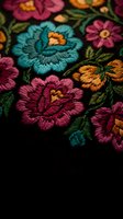 Colorful floral embroidery with vibrant roses and flowers on dark fabric showcasing traditional needlework craftsmanship and decorative textile art.