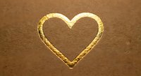 Golden heart shape embossed on brown leather texture background for luxury romantic design projects and Valentine's Day decorations.