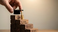 Hand placing a graduation cap on wooden staircase blocks engraved with Learn, Grow, Achieve, Great, symbolizing education and career success.