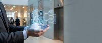 Businessman holding holographic digital technology icons in modern office environment showcasing innovation and futuristic business solutions.