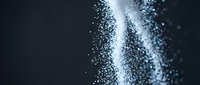 White powder explosion burst against dark background creating dynamic motion effect for cosmetic beauty product advertising campaigns.