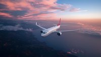 Commercial passenger aircraft flying over ocean at sunset with dramatic pink clouds and coastline view, representing air travel and transportation industry.