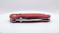 Red folding pocket knife with multiple tools closed on white background isolated for product photography and commercial use.