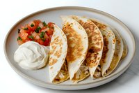 Mexican quesadillas with melted cheese served on gray ceramic plate with fresh tomato salsa and sour cream, traditional appetizer on white background.