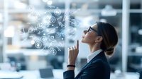 Young Caucasian businesswoman in suit pointing up while social media icons and emojis float above, representing digital communication and modern workplace connectivity.