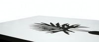 Brush stroke creating dynamic black ink splatter on white surface, suitable for graphic design and artistic projects.