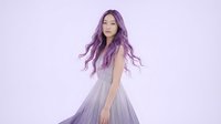 Young Asian woman with long purple hair wearing elegant gray dress on soft lavender background for fashion and beauty concepts.