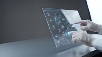 Medical professional using futuristic transparent tablet with holographic interface displaying healthcare data and digital icons for modern technology.