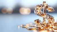 Dollar sign symbol made of transparent material with glowing golden lights inside on blurred background with bokeh effect.