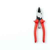 Red handled pliers tool isolated on white background for construction repair maintenance and DIY projects with copy space.