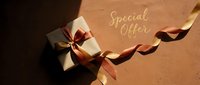 Elegant gift box with brown and gold ribbon on warm textured background with Special Offer text, perfect for holiday promotions.