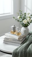 Cozy home interior with herbal tea, white flowers, books and knitted blanket on coffee table near window creating peaceful atmosphere for relaxation.