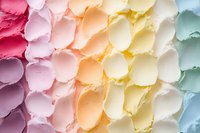 Colorful pastel buttercream frosting swirls arranged in rainbow gradient pattern, showing smooth creamy texture and decorative piping technique for cake decoration.