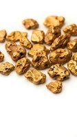 Raw gold nuggets scattered on white background showing natural metallic texture and irregular shapes for mining and precious metals concepts.