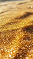 Macro view of golden sand with water droplets glistening in sunlight, creating a sparkling beach texture for luxury travel backgrounds.