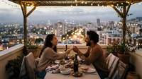 Young couple enjoying romantic dinner on rooftop terrace with city lights view at dusk. Intimate dining experience with string lights and urban skyline backdrop.
