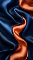 Luxurious flowing silk fabric in navy blue and copper colors creates elegant waves and folds with dramatic lighting effects and smooth texture for fashion backgrounds.