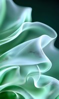 Soft flowing mint green and white silk fabric creates elegant waves and folds against dark background, showcasing luxurious textile movement and gentle curves.