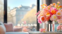 Elegant floral arrangement with pink and peach roses in metallic vase on table by window with soft natural light creating warm romantic atmosphere for home decor.
