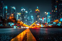 Blurred city street at night with colorful bokeh lights and wet asphalt reflecting urban illumination creating atmospheric downtown scene.