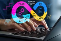 Business professional implementing PDCA cycle methodology on laptop for continuous improvement and quality management processes in corporate environment.