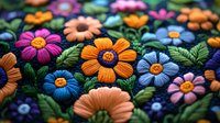 Colorful embroidered flowers with vibrant petals and green leaves on dark fabric, perfect for textile design, craft projects, and decorative backgrounds.