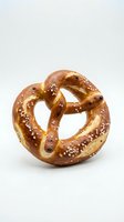 Freshly baked pretzel with coarse salt crystals on white background, isolated and ready for food, bakery, and culinary design projects.
