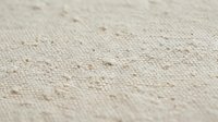 Natural beige linen fabric texture with visible fibers and organic weave pattern for textile backgrounds and rustic design projects.