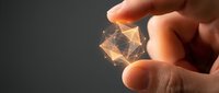 Hand holding glowing geometric wireframe structure against dark background, representing digital innovation, technology, data connectivity, and network solutions for business applications.