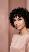 Young mixed-race woman with curly black hair and winged eyeliner wearing pink top against soft pink background for beauty and fashion concepts.